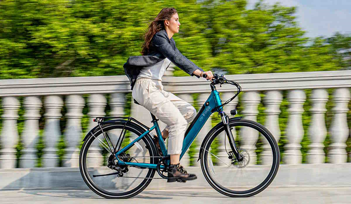 Une femme qui roule en vélo sur un pont