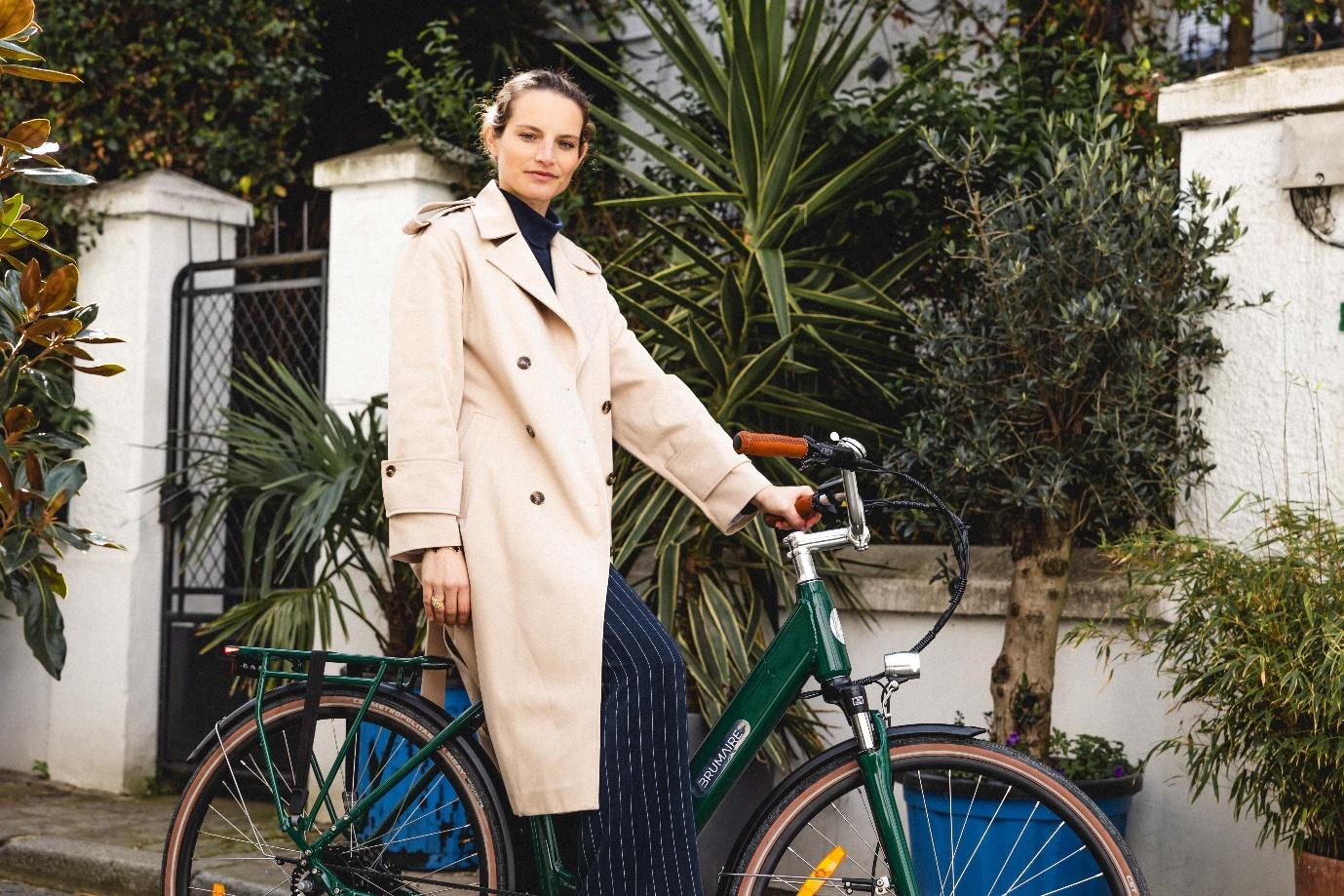 Une femme qui tient un vélo électrique de ville vert
