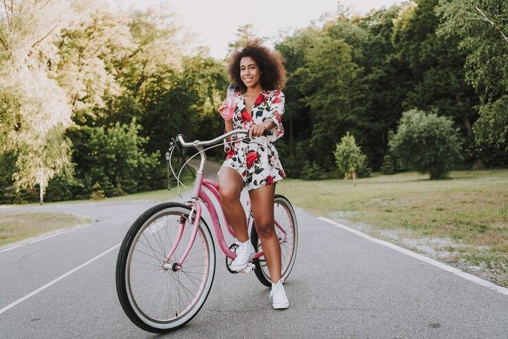 Une femme sur son vélo électrique au milieu d'une route en forêt