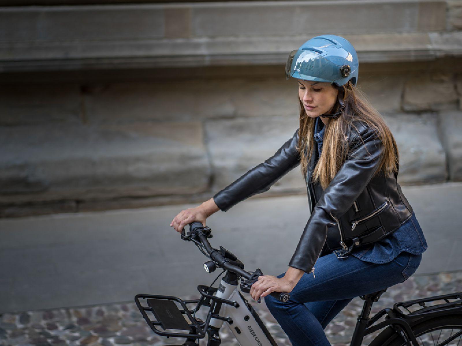 Un femme qui roule à vélo avec un casque bleu