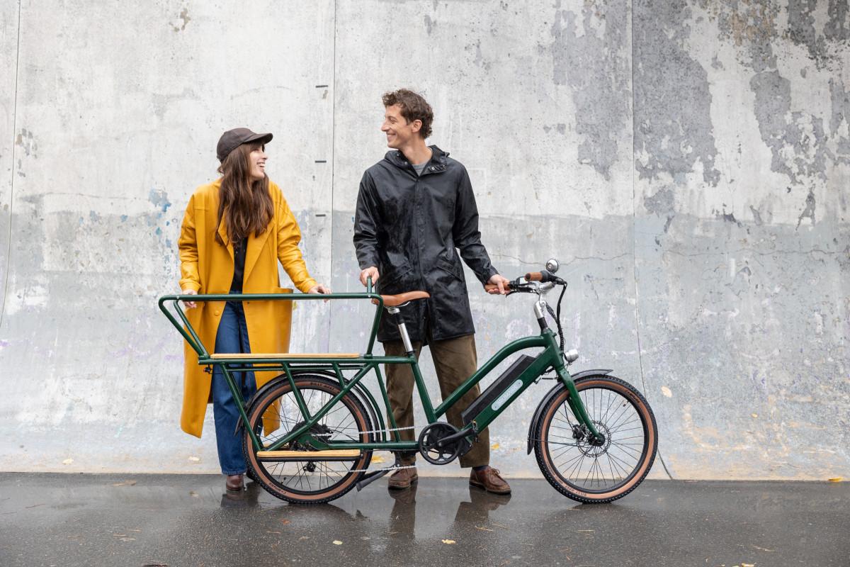 Deux personnes derrière un vélo électrique cargo