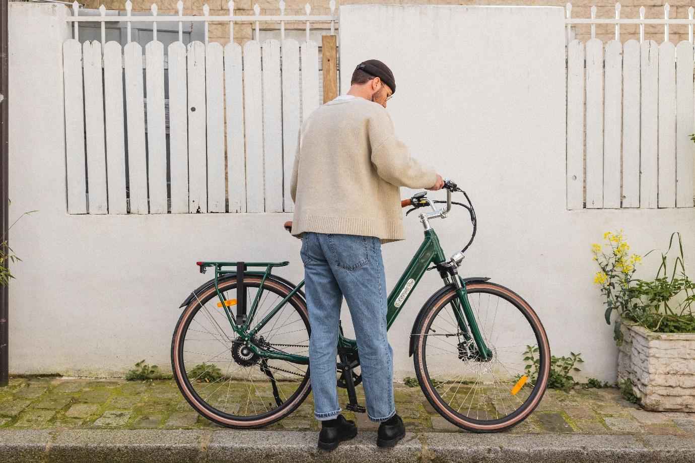 Un homme qui tient un vélo électrique de ville