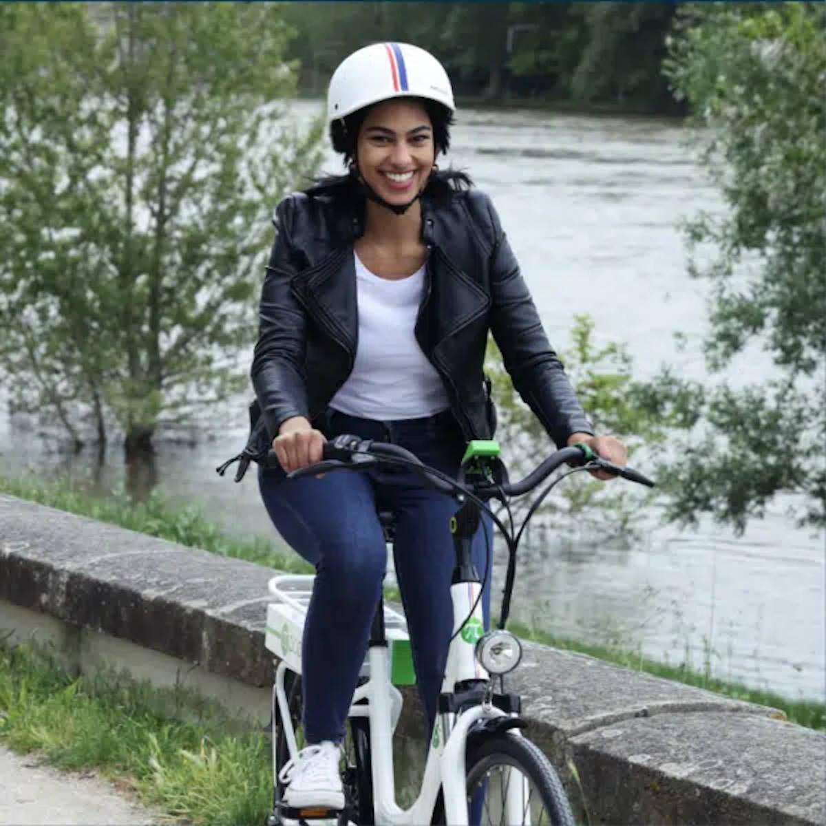 Une femme à bord d'un vélo électrique au bord d'un lac