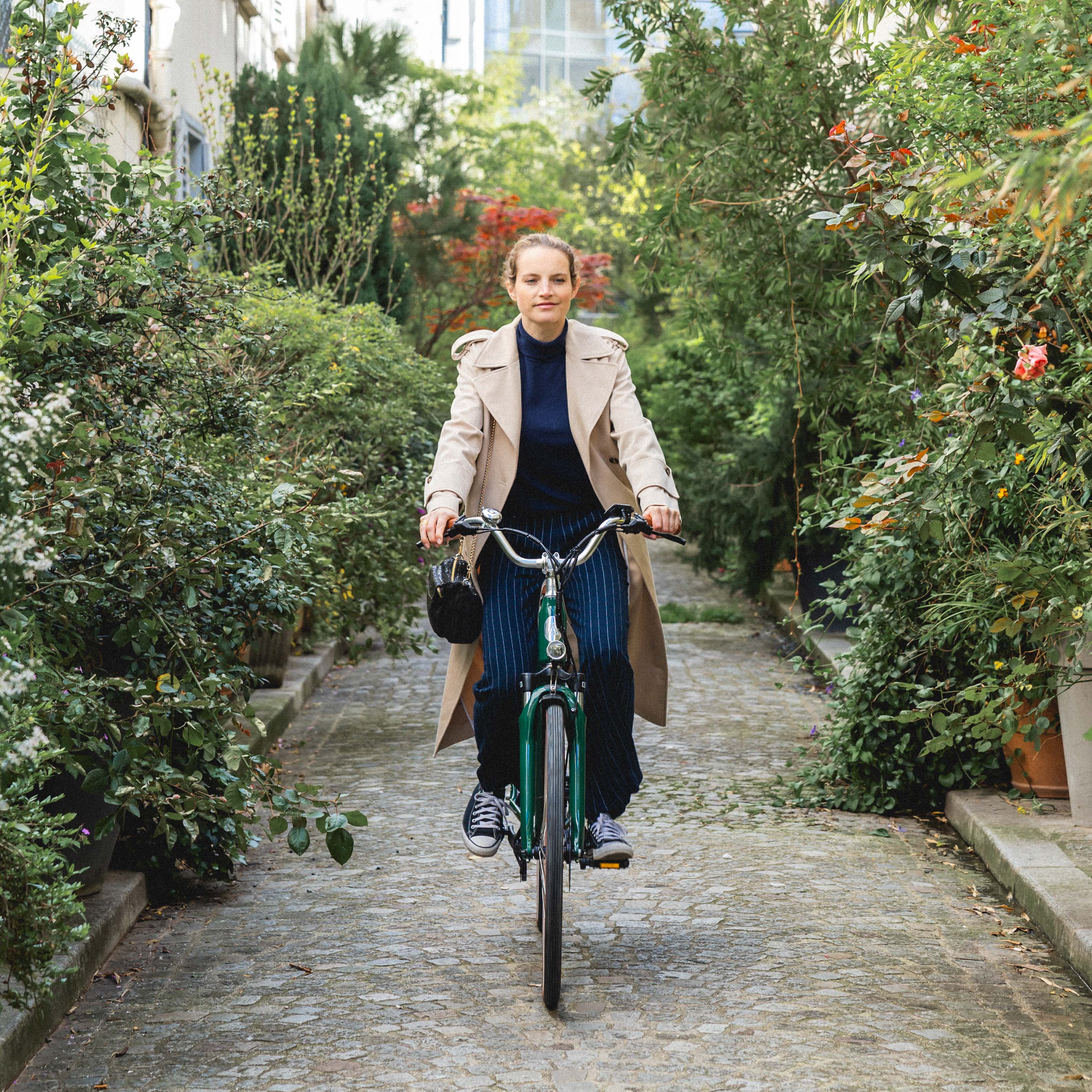 Une femme dans une ruelle avec un vélo électrique de ville