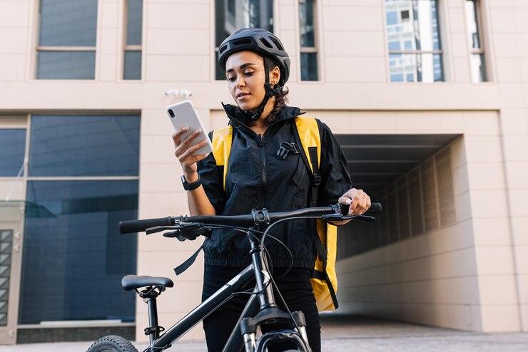 Une femme sur son téléphone assise sur un vélo électrique